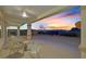 Covered patio with ceiling fan and comfortable furniture with views of the city and mountains at sunset at 3042 Lake Barkley Rd, Henderson, NV 89052