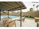 Backyard features a covered patio with a swimming pool, lounge chairs, and landscaped plants at 3119 Desmond Ave, Las Vegas, NV 89121