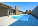 Beautiful pool with clear blue water surrounded by concrete and a tall cinderblock fence at 3119 Desmond Ave, Las Vegas, NV 89121