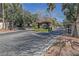 View of a guard-gated entry with desert landscaping and mature trees at 3422 Pino Cir, Las Vegas, NV 89121