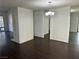 Bright living area with dark floors, white walls, a modern chandelier, and a decorative fireplace at 3422 Pino Cir, Las Vegas, NV 89121