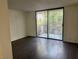 Bright living room featuring dark wood floors and large sliding glass doors to private patio at 3422 Pino Cir, Las Vegas, NV 89121