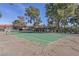View of fenced in community tennis court in maturely landscaped area at 3422 Pino Cir, Las Vegas, NV 89121
