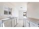Functional kitchen featuring tile floors, white cabinets, stainless steel sink, and windows at 3704 Haddock Ave, North Las Vegas, NV 89030