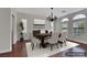 Staged dining room includes wood table, six chairs, chandelier and three windows covered in white shutters at 3728 White Lion Ln, North Las Vegas, NV 89084