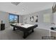 This virtually staged game room features a pool table and access to a patio at 3728 White Lion Ln, North Las Vegas, NV 89084
