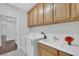 Spacious laundry room featuring utility sink, wooden cabinets, washer, and dryer at 3728 White Lion Ln, North Las Vegas, NV 89084