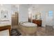 Bright bathroom featuring dual sinks, a walk-in shower, and a large soaking tub at 537 Blanche Ct, Henderson, NV 89052