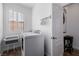 Well-lit laundry room featuring modern washer and dryer units and a folding table at 537 Blanche Ct, Henderson, NV 89052