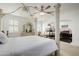 Bright bedroom with a four-poster bed, ceiling fan, and a fireplace feature at 537 Blanche Ct, Henderson, NV 89052