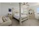 Bright bedroom with a four-poster bed, a ceiling fan, dresser, and a comfortable love seat at 537 Blanche Ct, Henderson, NV 89052