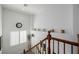 Staircase with a clock and decorations on a ledge, wood railing, and a window providing natural light at 537 Blanche Ct, Henderson, NV 89052