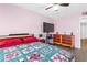 Bright bedroom with pink walls, a ceiling fan, and a large bed with colorful patterned bedding at 5710 E Tropicana Ave # 1166, Las Vegas, NV 89122