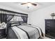 Bedroom features a large bed with black and grey linens, black curtains, and a dark dresser at 5710 E Tropicana Ave # 1166, Las Vegas, NV 89122