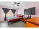 Bedroom featuring a ceiling fan, large window with dark curtains, and a television mounted on the wall at 5710 E Tropicana Ave # 1166, Las Vegas, NV 89122