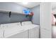 Practical laundry room with a washer and dryer, overhead shelf, and a white louvered door at 5710 E Tropicana Ave # 1166, Las Vegas, NV 89122