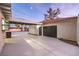 View of the house's side exterior featuring two garage doors and ample driveway space at 5750 Edna Ave, Las Vegas, NV 89146