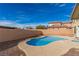 Backyard features a pool with a concrete perimeter and a tall wall in the background at 5861 Lakeland Village Dr, North Las Vegas, NV 89081