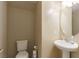 Cozy powder room featuring a pedestal sink, toilet, and neutral color palette at 5861 Lakeland Village Dr, North Las Vegas, NV 89081