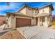 Charming two-story home featuring a two-car garage and a welcoming covered porch with stylish architectural details at 5861 Lakeland Village Dr, North Las Vegas, NV 89081