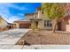 Two-story home featuring an attached two-car garage, a covered porch, and water-efficient landscaping for a modern lifestyle at 5861 Lakeland Village Dr, North Las Vegas, NV 89081