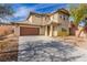 Charming two-story home showcasing a well-manicured lawn and a spacious driveway leading to a two-car garage at 5861 Lakeland Village Dr, North Las Vegas, NV 89081