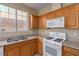 Bright kitchen showcasing wood cabinets, granite countertops, and modern white appliances under natural light at 5861 Lakeland Village Dr, North Las Vegas, NV 89081