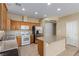 Spacious kitchen features tile floors, a center island, wood cabinets, and stainless steel appliances at 5861 Lakeland Village Dr, North Las Vegas, NV 89081