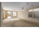 Bright living room with carpet, ceiling fan, and sliding door access to the backyard pool at 5861 Lakeland Village Dr, North Las Vegas, NV 89081