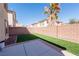 Backyard with a brick wall, artificial turf, a palm tree and a concrete patio at 6036 Sierra Lakes St, North Las Vegas, NV 89031