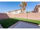 Backyard with a brick wall, artificial turf, a palm tree and a concrete patio at 6036 Sierra Lakes St, North Las Vegas, NV 89031