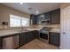 Well-lit kitchen features stainless steel appliances and dark cabinetry at 6036 Sierra Lakes St, North Las Vegas, NV 89031