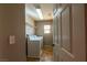 A laundry room with white washer and dryer, wire shelving, and neutral walls, providing a tidy space at 6036 Sierra Lakes St, North Las Vegas, NV 89031