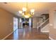 Open-concept living room with hardwood floors that flows into kitchen and staircase at 6036 Sierra Lakes St, North Las Vegas, NV 89031