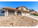 Inviting two-story home featuring desert landscaping, a terracotta tile roof, and a two-car garage on a sunny day at 6320 Peppermill Dr, Las Vegas, NV 89146