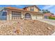 Inviting two-story home featuring desert landscaping, a terracotta tile roof, and a two-car garage on a sunny day at 6320 Peppermill Dr, Las Vegas, NV 89146