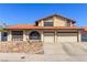 Front exterior featuring a three-car garage, desert landscaping, and blue skies at 6320 Peppermill Dr, Las Vegas, NV 89146