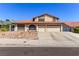 Exterior shot of home with three-car garage and desert landscaping at 6320 Peppermill Dr, Las Vegas, NV 89146