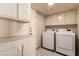 Bright laundry room featuring white cabinets, counter, washer and dryer at 6320 Peppermill Dr, Las Vegas, NV 89146