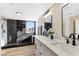 Beautiful bathroom featuring double sinks, a marble countertop, and a modern walk-in shower with black accents at 6628 Silver Penny Ave, Las Vegas, NV 89108