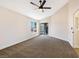 Bedroom with fan, neutral carpet, and sliding glass doors to a balcony at 6628 Silver Penny Ave, Las Vegas, NV 89108