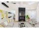Bright and spacious living room featuring a fireplace with mounted TV, light hardwood floors, and comfortable seating at 6628 Silver Penny Ave, Las Vegas, NV 89108