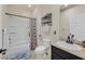 Well-lit bathroom with a shower-tub combo, granite sink, and neutral wall color at 748 Canfield Point Ave, Las Vegas, NV 89183