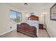 Bright bedroom with a decorative wooden bed frame and a large window allowing natural light at 748 Canfield Point Ave, Las Vegas, NV 89183