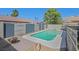 Backyard swimming pool with a spa, decorative rock features, and colorful fencing at 748 Canfield Point Ave, Las Vegas, NV 89183