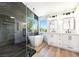 Modern bathroom boasts a freestanding tub, glass-enclosed shower, and sleek fixtures at 7832 Desert Candle Way, Las Vegas, NV 89128