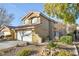 Charming two-story house with a spacious two-car garage, desert landscaping, and mature trees in the front yard at 7832 Desert Candle Way, Las Vegas, NV 89128
