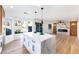 Open kitchen and living space with a waterfall island, and hardwood flooring at 7832 Desert Candle Way, Las Vegas, NV 89128