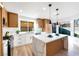 Bright kitchen features a waterfall island, stainless steel appliances, and white and wood cabinets at 7832 Desert Candle Way, Las Vegas, NV 89128