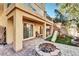 Inviting backyard patio with a fire pit, lush artificial turf, and play set at 8456 Blackstone Ridge Ct, Las Vegas, NV 89139